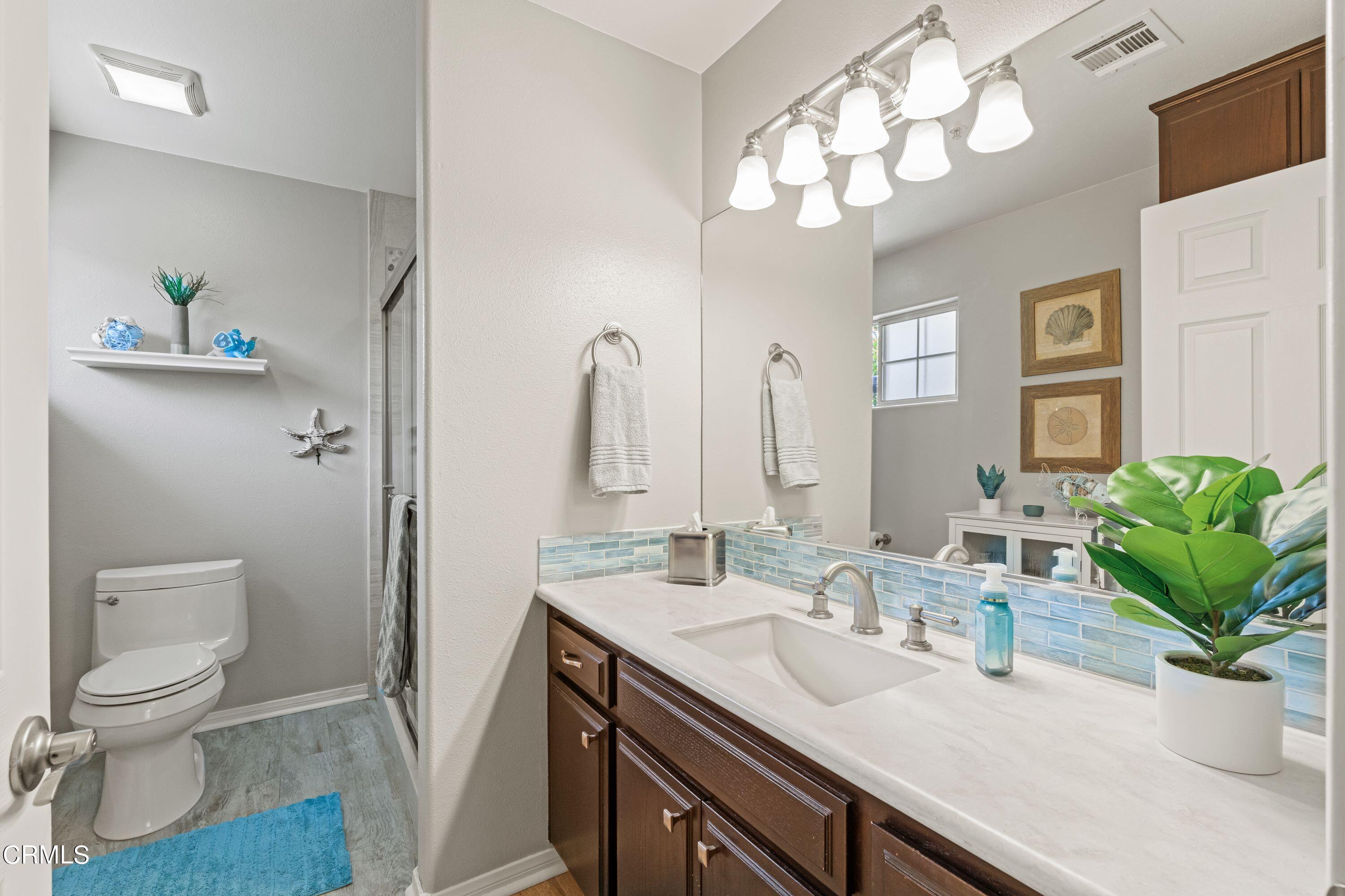 10975 Darling Road Ventura, CA 93004 - Photo 21 of 49 a bathroom with a granite countertop sink a toilet and a mirror