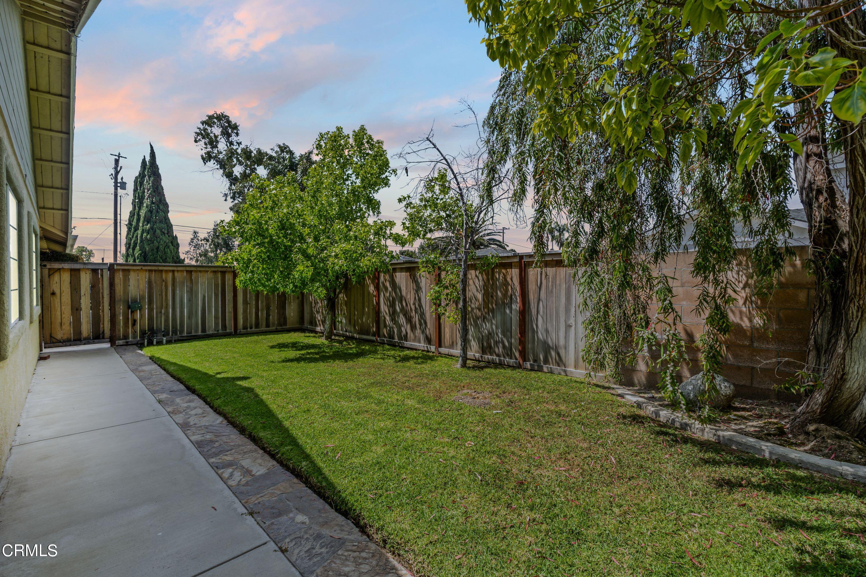 10975 Darling Road Ventura, CA 93004 - Photo 43 of 49 a view of a backyard with large trees and wooden fence