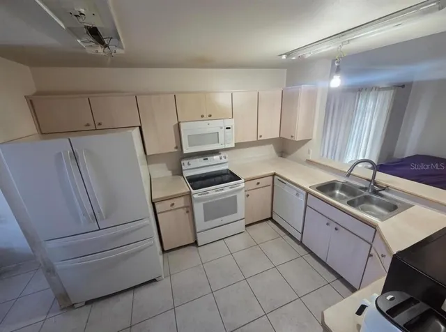 a kitchen with white cabinets and white appliances