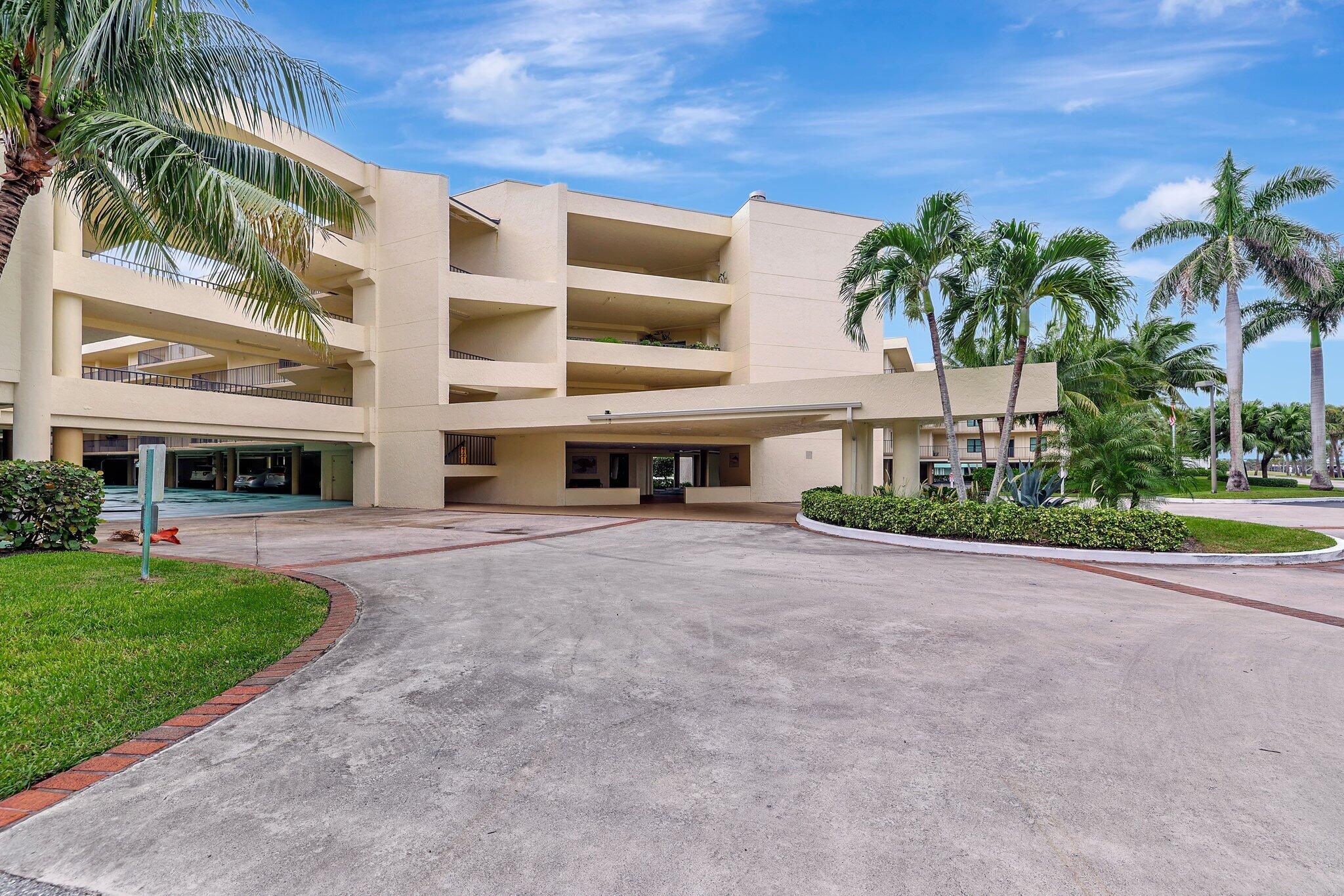 221 Northeast Plantation Road, Unit 406 Stuart, FL 34996 - Photo 2 of 58 a view of a building with a yard and palm trees