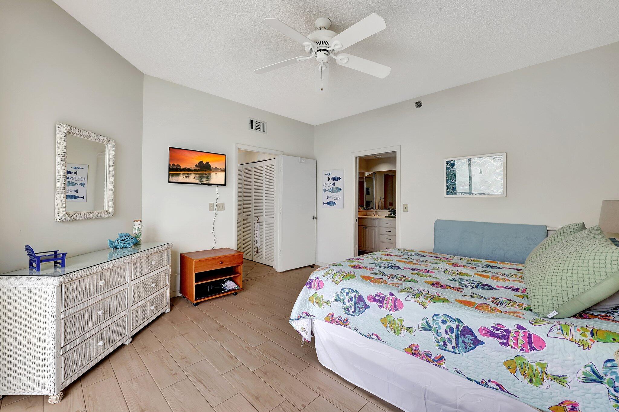 221 Northeast Plantation Road, Unit 406 Stuart, FL 34996 - Photo 26 of 58 a bedroom with a bed and a dresser in it