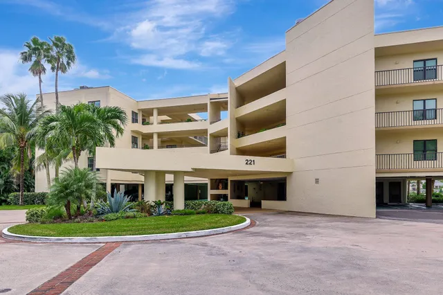a front view of a house with a yard and potted plants