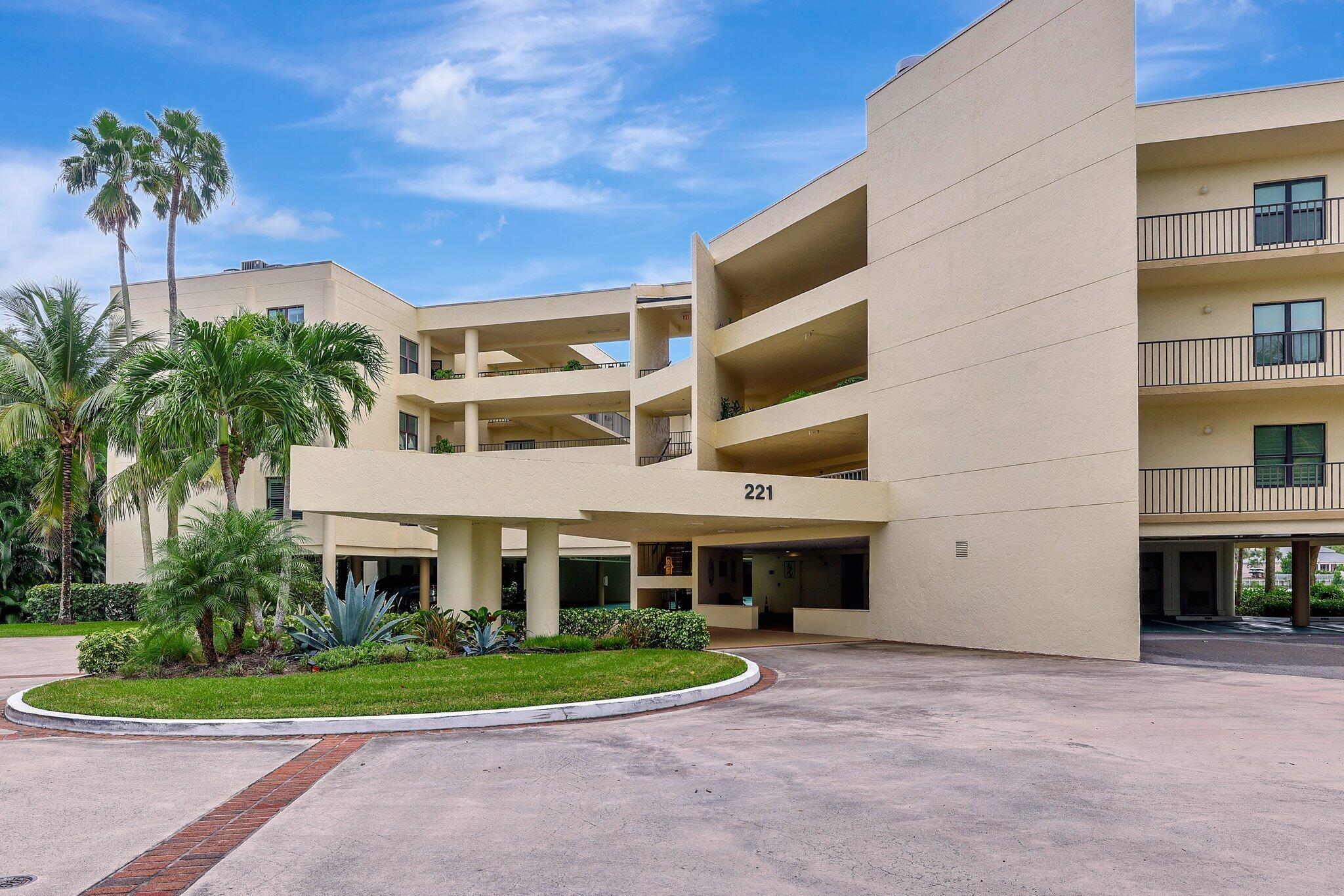 221 Northeast Plantation Road, Unit 406 Stuart, FL 34996 - Photo 4 of 58 a front view of a house with a yard and potted plants
