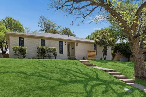 a view of a house with a yard and potted plants