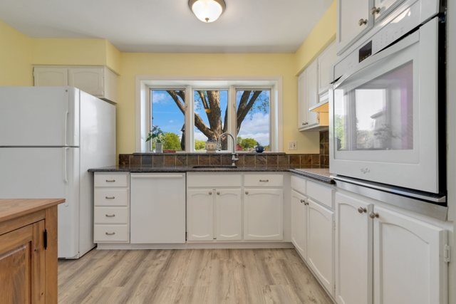 Undisclosed Address Buffalo Grove, IL 60089 - Photo 23 of 30 a kitchen with white cabinets and white appliances