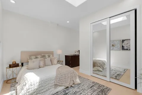 a bedroom with a bed and a potted plant