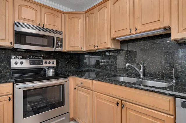 a kitchen with granite countertop a stove microwave and sink