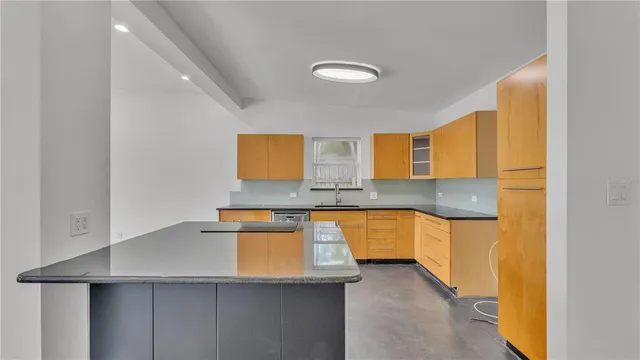 a kitchen with stainless steel appliances granite countertop white cabinets sink and window