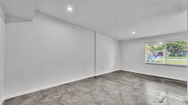 a view of a big room with wooden floor and windows