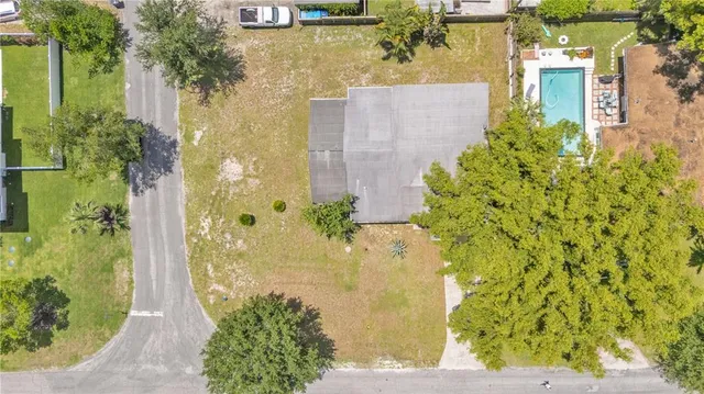 an aerial view of residential house with outdoor space and trees all around