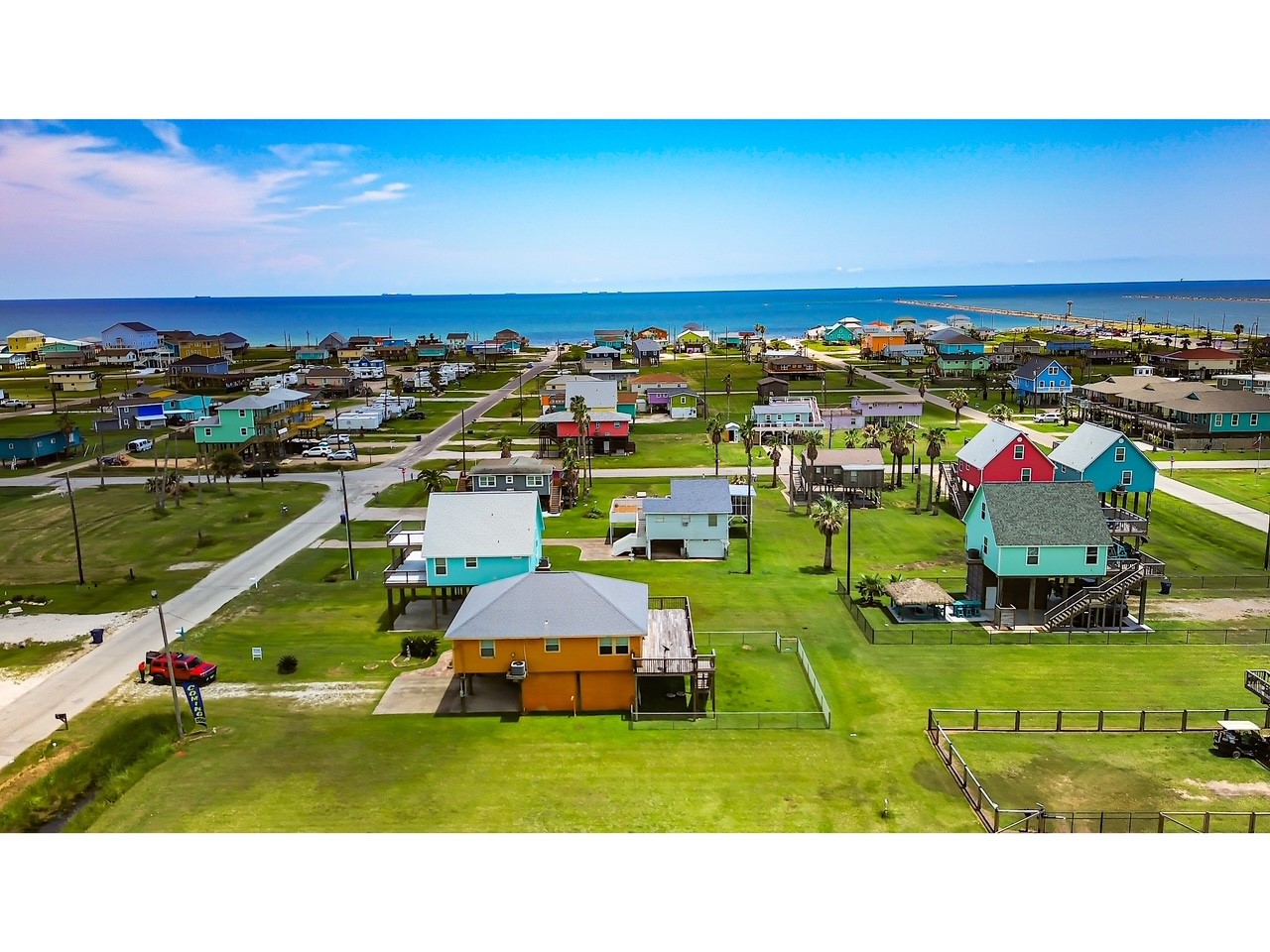 419 Thunder Road Surfside Beach, TX 77541 - Photo 28 of 32 Coastal neighborhood with colorful homes, lush green lawns, and ocean views. Ideal beachside living.