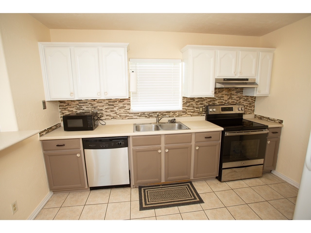 419 Thunder Road Surfside Beach, TX 77541 - Photo 9 of 32 Modern kitchen featuring stylish cabinetry, updated appliances, and a chic tile backsplash.