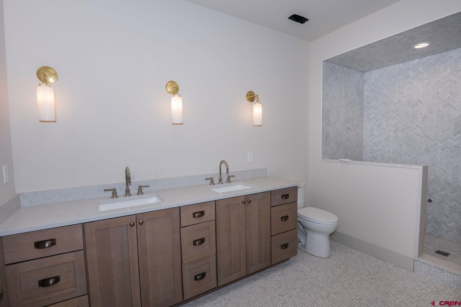 180 Elk Valley Road, Unit 105 Crested Butte, CO 81224 - Photo 14 of 35 a spacious bathroom with a toilet sink and mirror