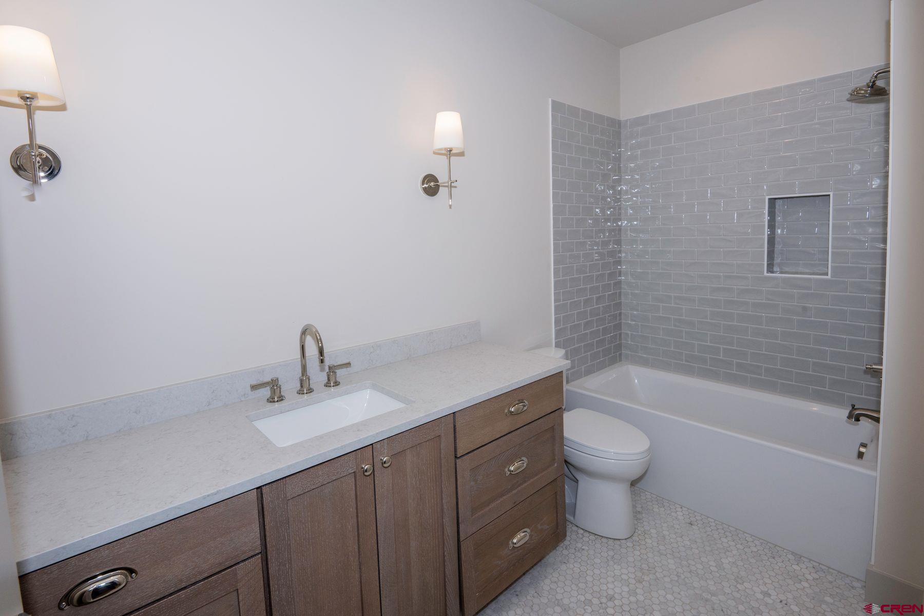 180 Elk Valley Road, Unit 105 Crested Butte, CO 81224 - Photo 23 of 35 a bathroom with a bathtub shower sink vanity and toilet