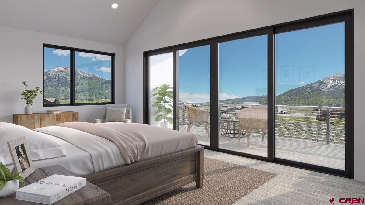 180 Elk Valley Road, Unit 105 Crested Butte, CO 81224 - Photo 31 of 35 a bedroom with a large window and a balcony