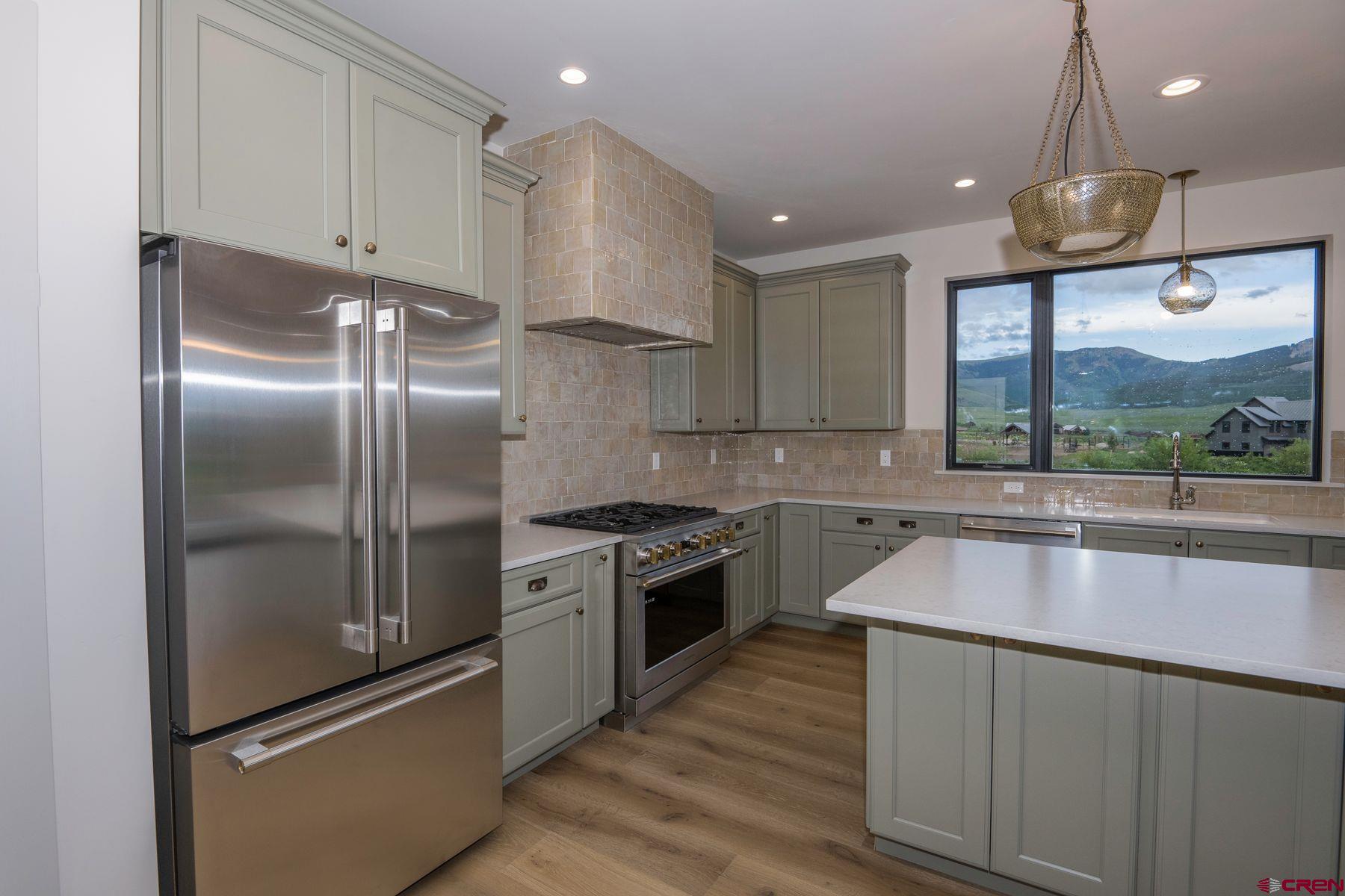 180 Elk Valley Road, Unit 105 Crested Butte, CO 81224 - Photo 6 of 35 a kitchen with kitchen island a counter top space a sink and stainless steel appliances