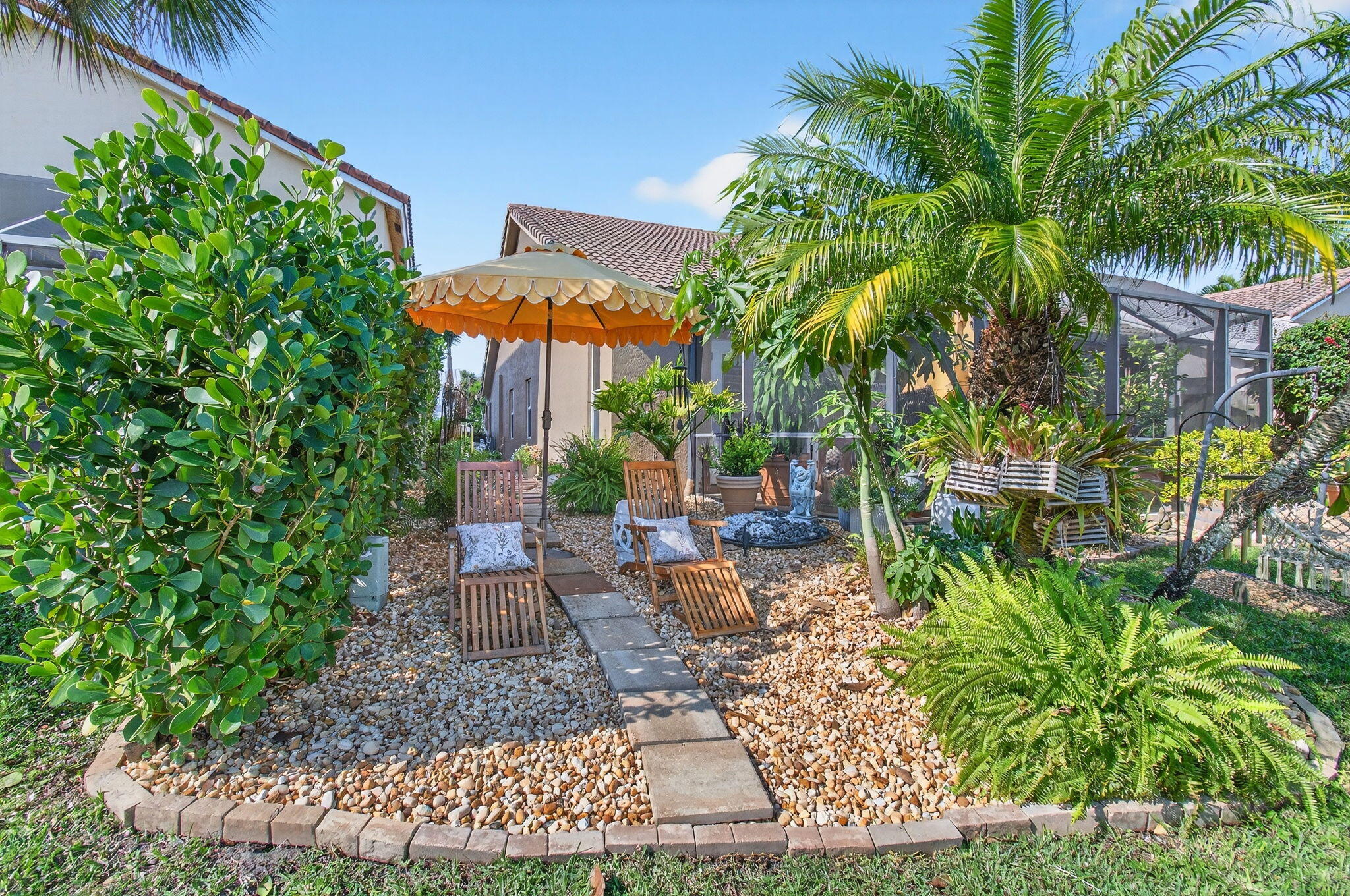 21400 Millbrook Court Boca Raton, FL 33498 - Photo 61 of 65 a view of a patio with table and chairs potted plants and palm tree