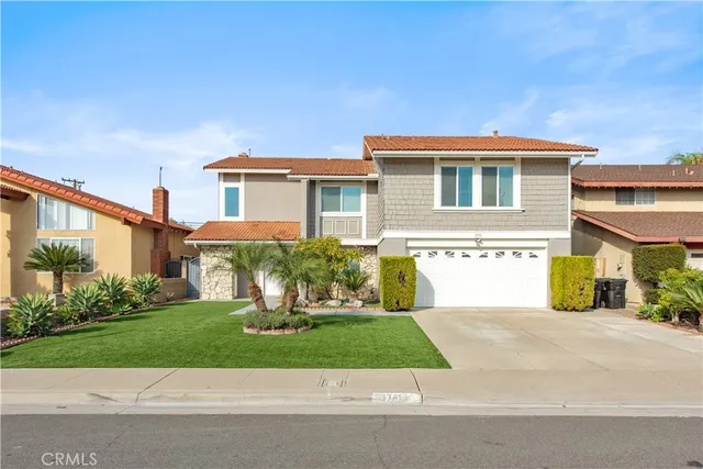 a front view of a house with a yard and potted plants