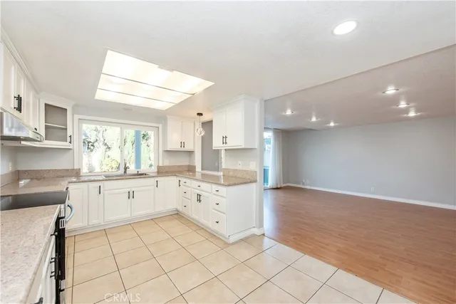 a large kitchen with granite countertop a white stove top oven and cabinets