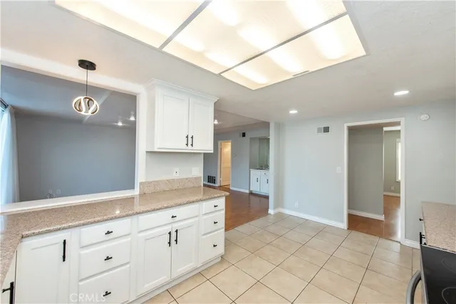 a kitchen with granite countertop white cabinets and white appliances