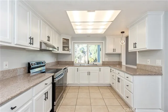 a kitchen with granite countertop white cabinets and white appliances