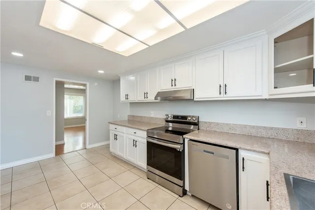 a kitchen with stainless steel appliances granite countertop a stove a sink and a refrigerator