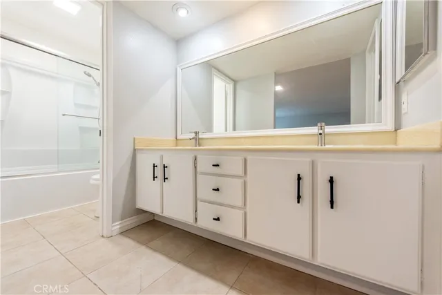 a spacious bathroom with a granite countertop sink a mirror and a bathtub