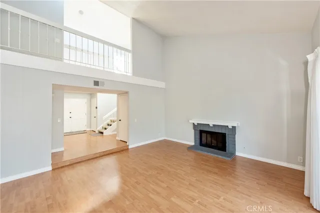 an empty room with a fireplace and wooden floor
