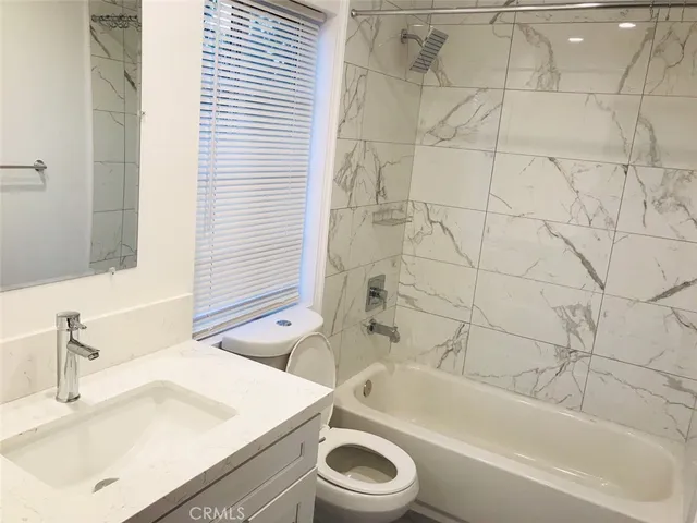 a bathroom with a sink a toilet and bathtub