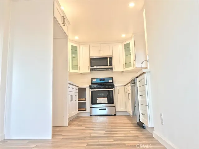 a kitchen with granite countertop a stove and a microwave