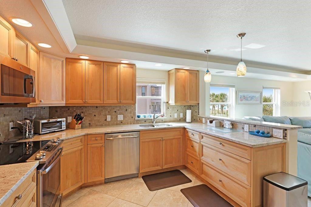 6154 Midnight Pass Road, Unit 201 Sarasota, FL 34242 - Photo 4 of 11 a kitchen with a sink stove and cabinets