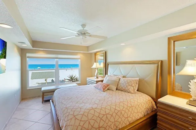 a bedroom with a large bed and a chandelier