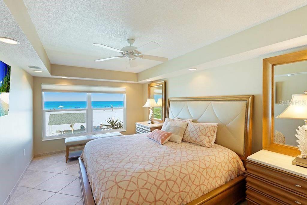 6154 Midnight Pass Road, Unit 201 Sarasota, FL 34242 - Photo 8 of 11 a bedroom with a large bed and a chandelier