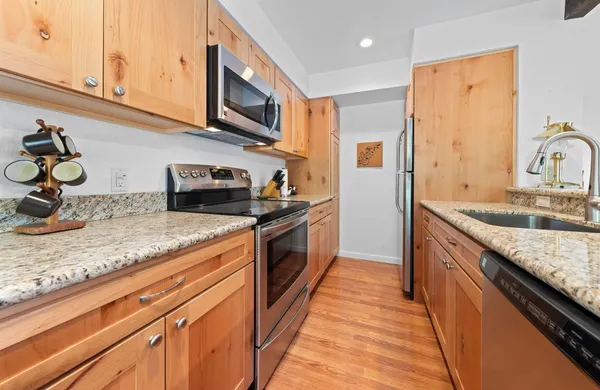 a kitchen with stainless steel appliances granite countertop a sink stove and refrigerator