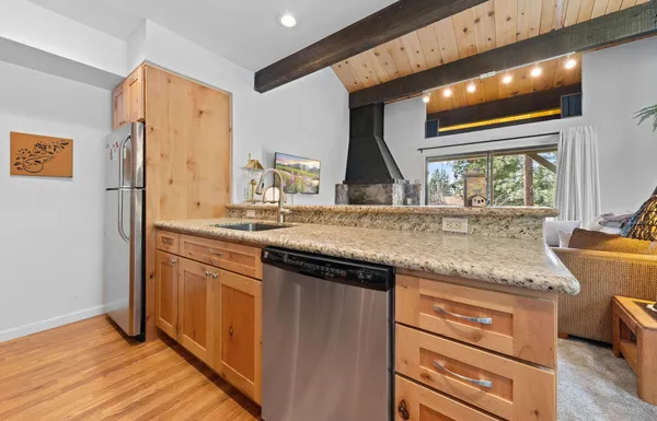 a kitchen with stainless steel appliances granite countertop a sink and a refrigerator