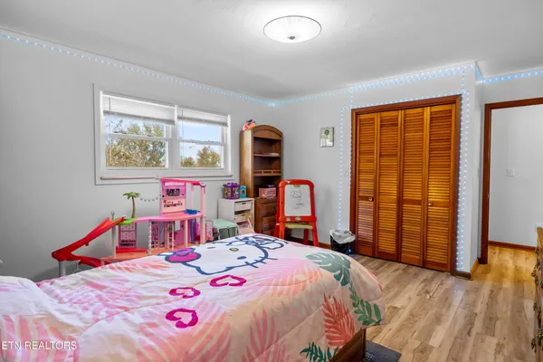 a bedroom with a bed and wooden floor