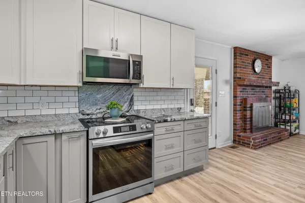 a kitchen with stainless steel appliances granite countertop a stove sink and cabinets