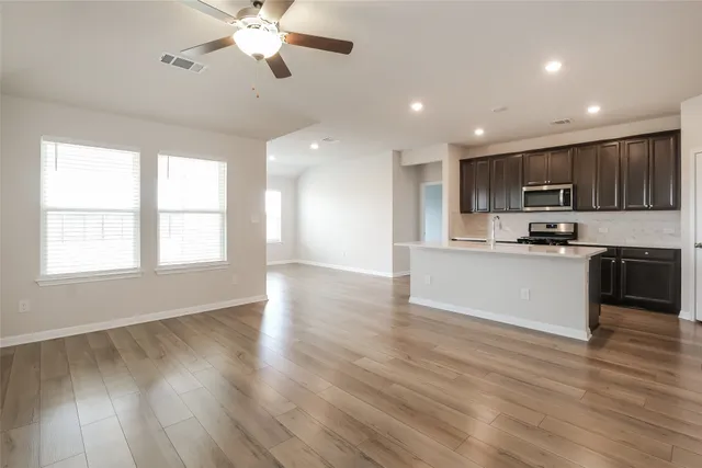 a view of kitchen with sink a microwave and wooden floor