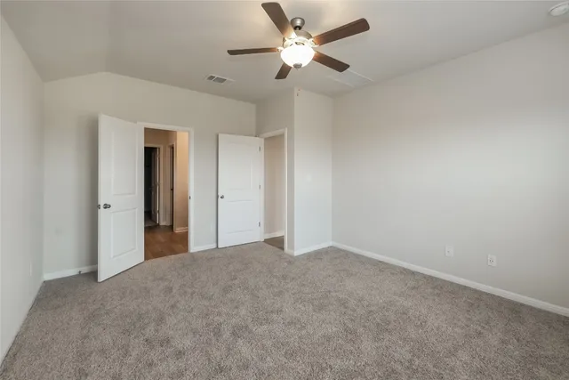 a view of an empty room and a ceiling fan