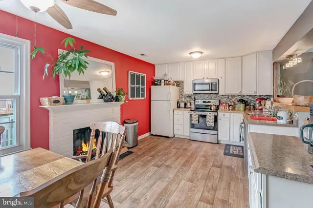 a kitchen with a table chairs refrigerator and microwave