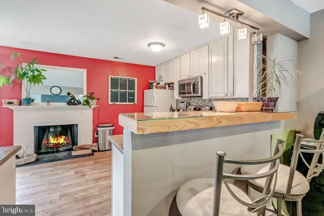 a living room with furniture a fireplace with kitchen view