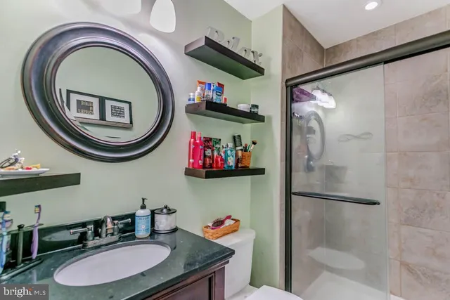 a bathroom with a sink a mirror and a shower