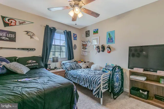 a bedroom with two beds and a flat screen tv