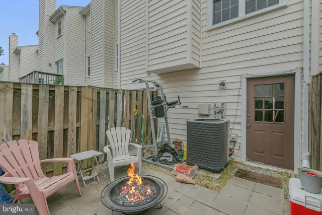 a backyard of a house with fire pit and outdoor seating