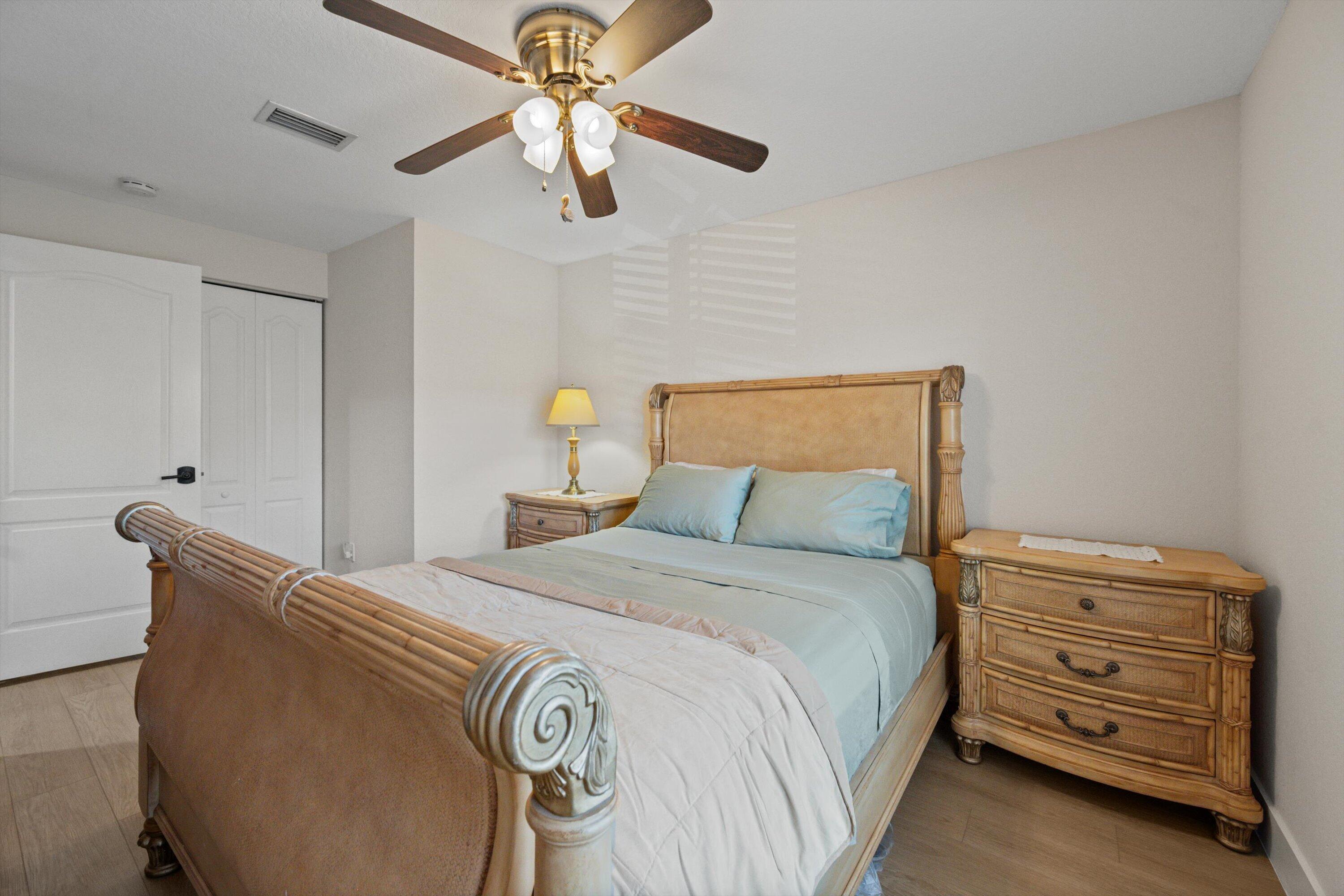 6058 Seminole Gardens Circle Riviera Beach, FL 33418 - Photo 22 of 47 a bedroom with a bed and ceiling fan