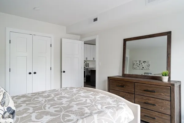 a bedroom with a bed and a mirror on dresser