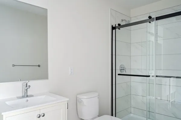 a bathroom with a toilet sink vanity and shower