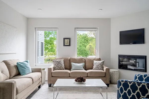 a living room with furniture a flat screen tv and a fireplace
