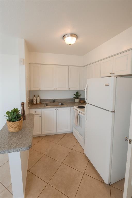 1960 Northeast 48th Street, Unit 12 Pompano Beach, FL 33064 - Photo 2 of 5 a kitchen with white cabinets and white appliances