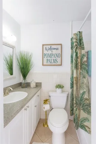 a bathroom with a granite countertop toilet sink and mirror